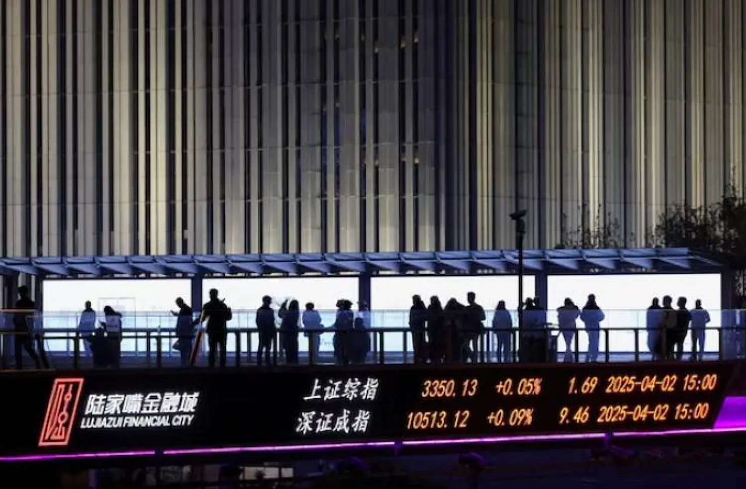 لوحة تعرض مؤشرات شنغهاي وشنتشن على جسر مشاة في حي لوجيازو المالي، شنغهاي (رويترز)