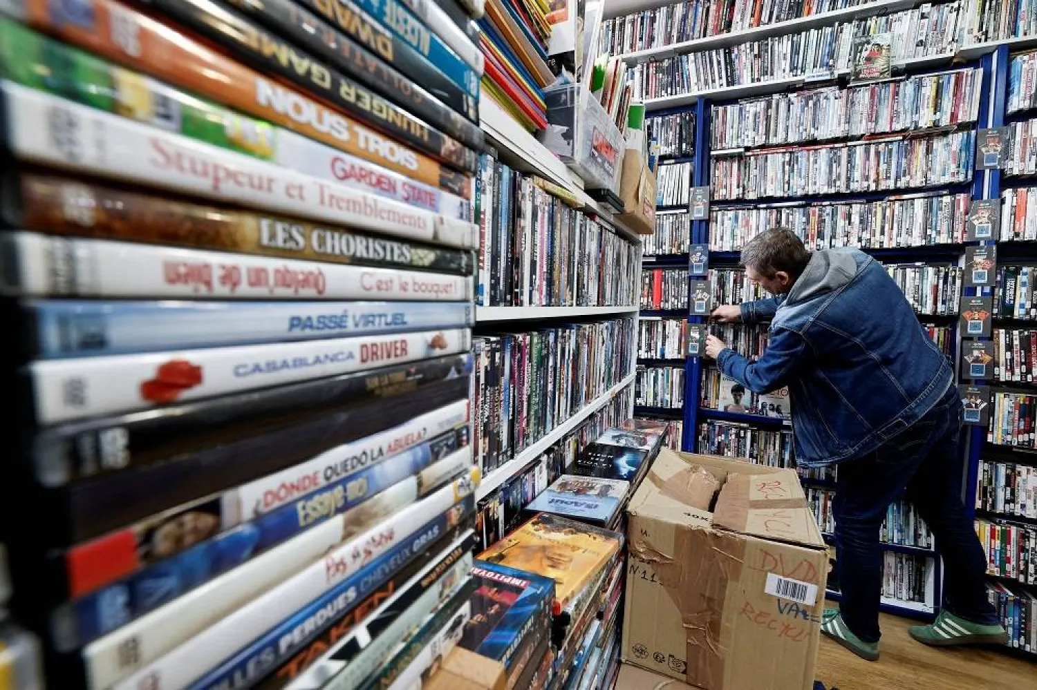 A man browses some DVD releases for rent at JM Video, a video rental store, which is facing financial difficulties, in Paris, France, September 13, 2025. (Reuters)