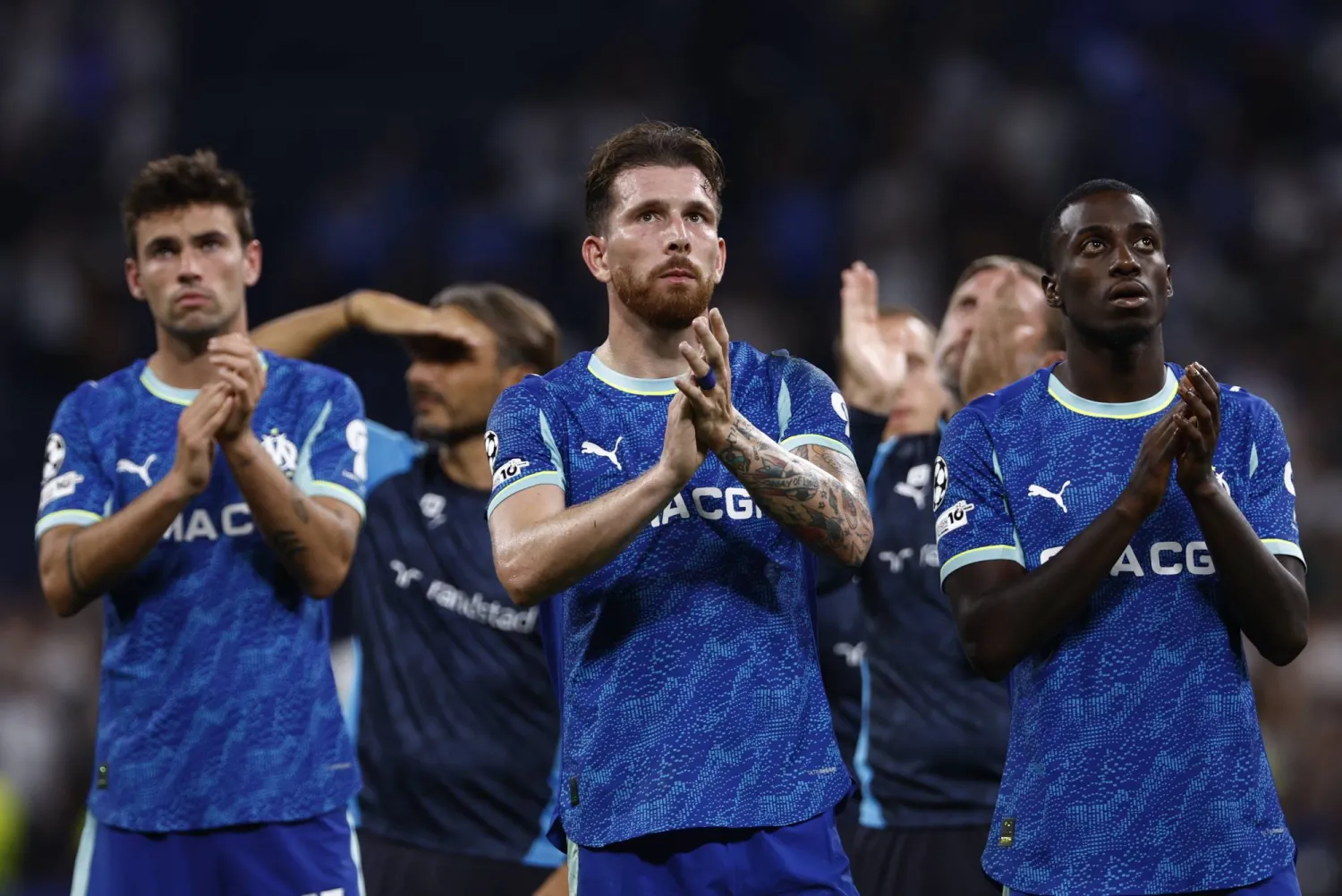 لاعبو أولمبيك مرسيليا يحيّون جماهيرهم بعد الخسارة في مباراة دوري أبطال أوروبا أمام الريال (إ.ب.أ)