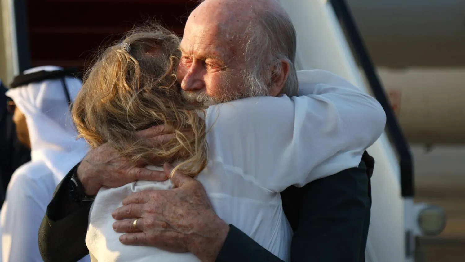 Peter Reynolds hugs his daughter Sarah Entwistle after landing at Doha following the Taliban's release of him and his wife. Karim JAAFAR / AFP
