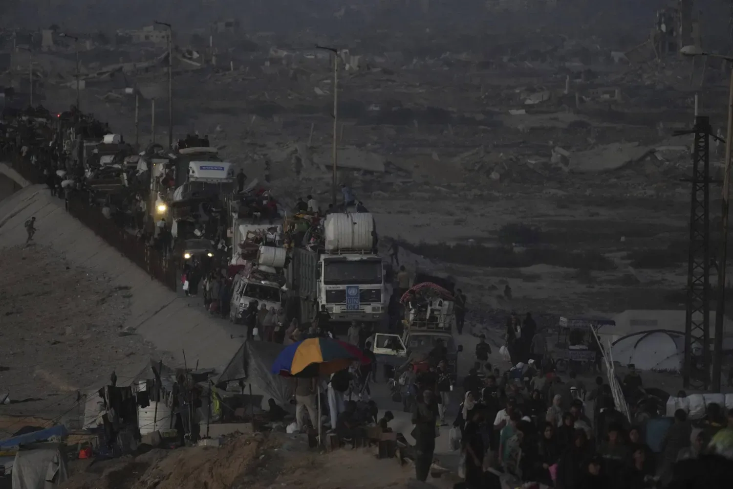Yerinden edilmiş Filistinliler, eşyalarını Nuseyrat'taki sahil yolundan güney Gazze Şeridi'ne doğru yaya ve araçlarla taşıyarak Gazze Şehri'nden kaçıyor (AP)
