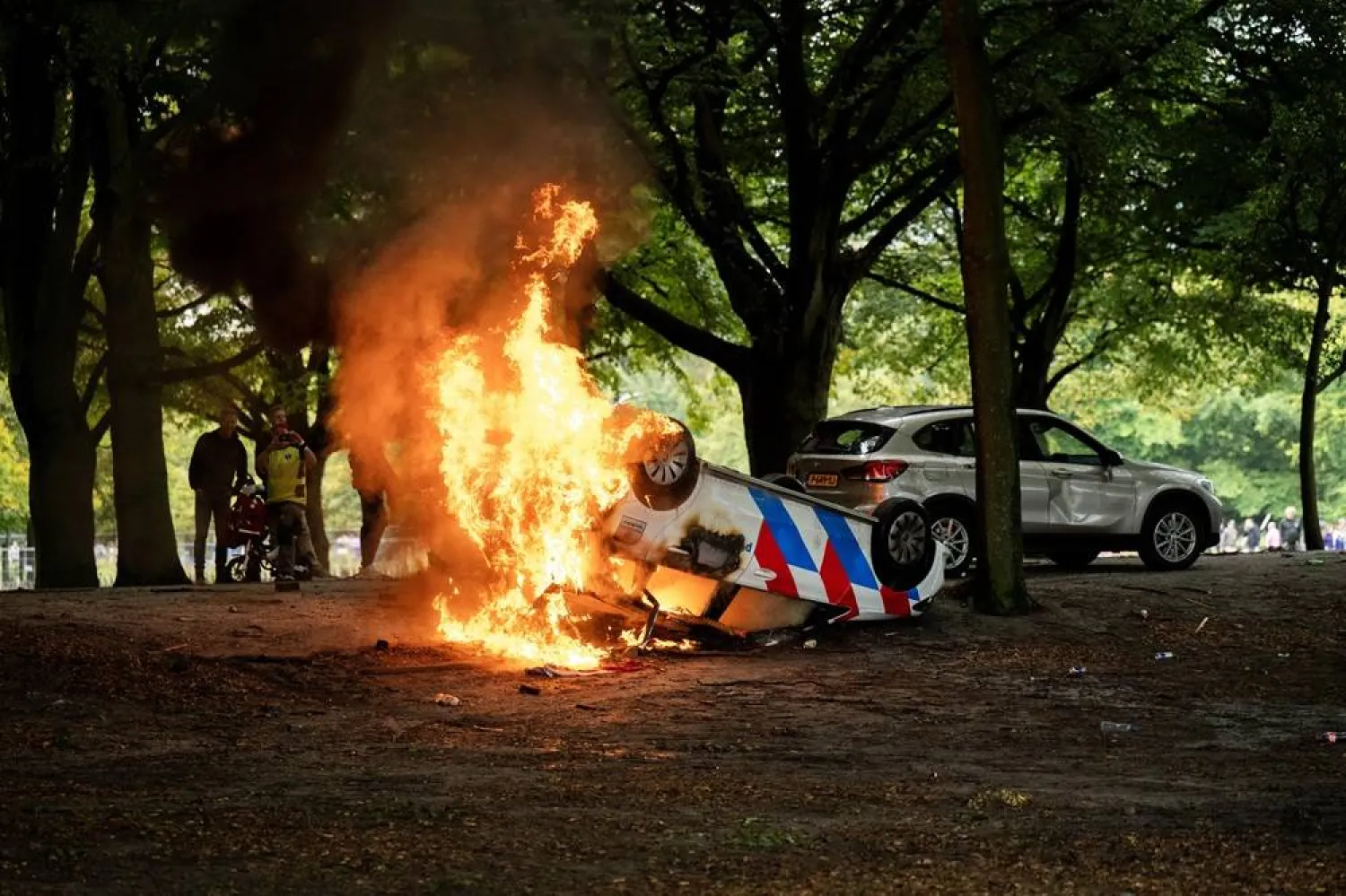 A police car is set on fire during a protest against the current asylum policy on the Malieveld, in the Hague, the Netherlands, 20 September 2025. (EPA)
