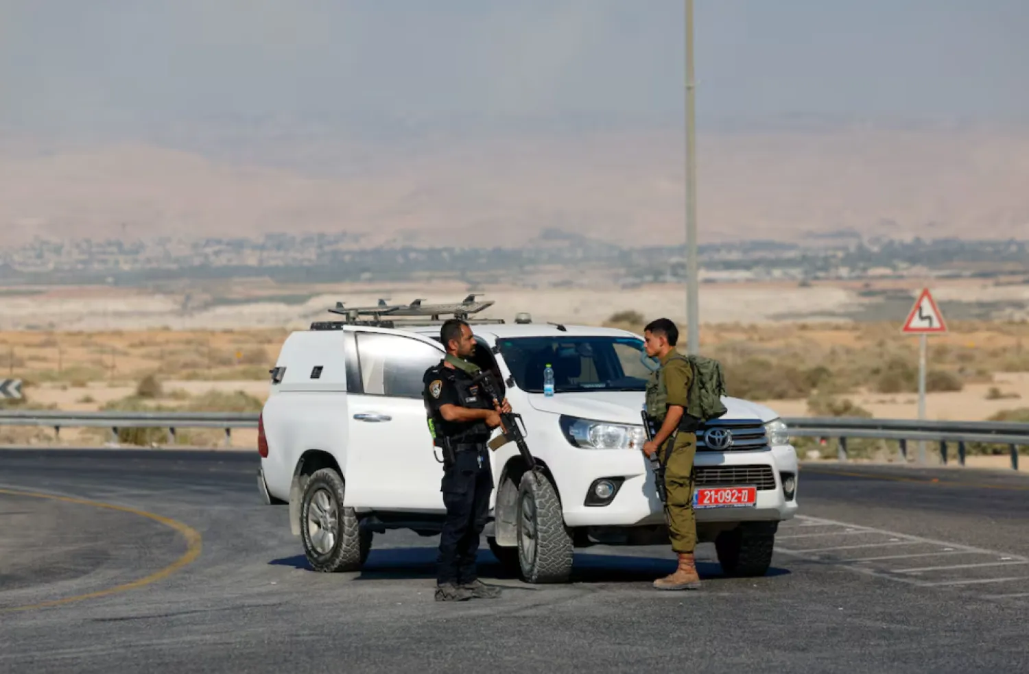 An Israeli police officer and soldier hold firearms, at the scene of a shooting at the Allenby Crossing between the Israeli-Occupied West Bank and Jordan, September 18, 2025. REUTERS/Oren Ben Hakoon 