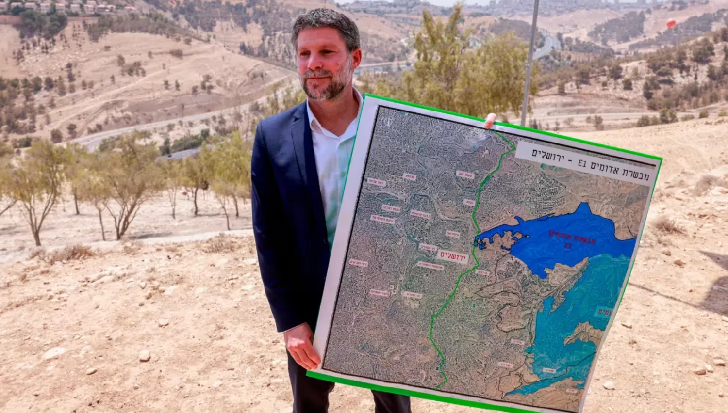 Bezalel Smotrich with a map of a proposed settlement area - © Menahem Kahana/AFP/Getty Images