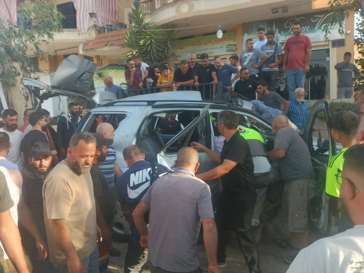 عناصر الدفاع المدني يحاول إنقاذ مواطنين في السيارة التي استهدفت بقصف إسرائيلي في بنت جبيل (الشرق الأوسط)