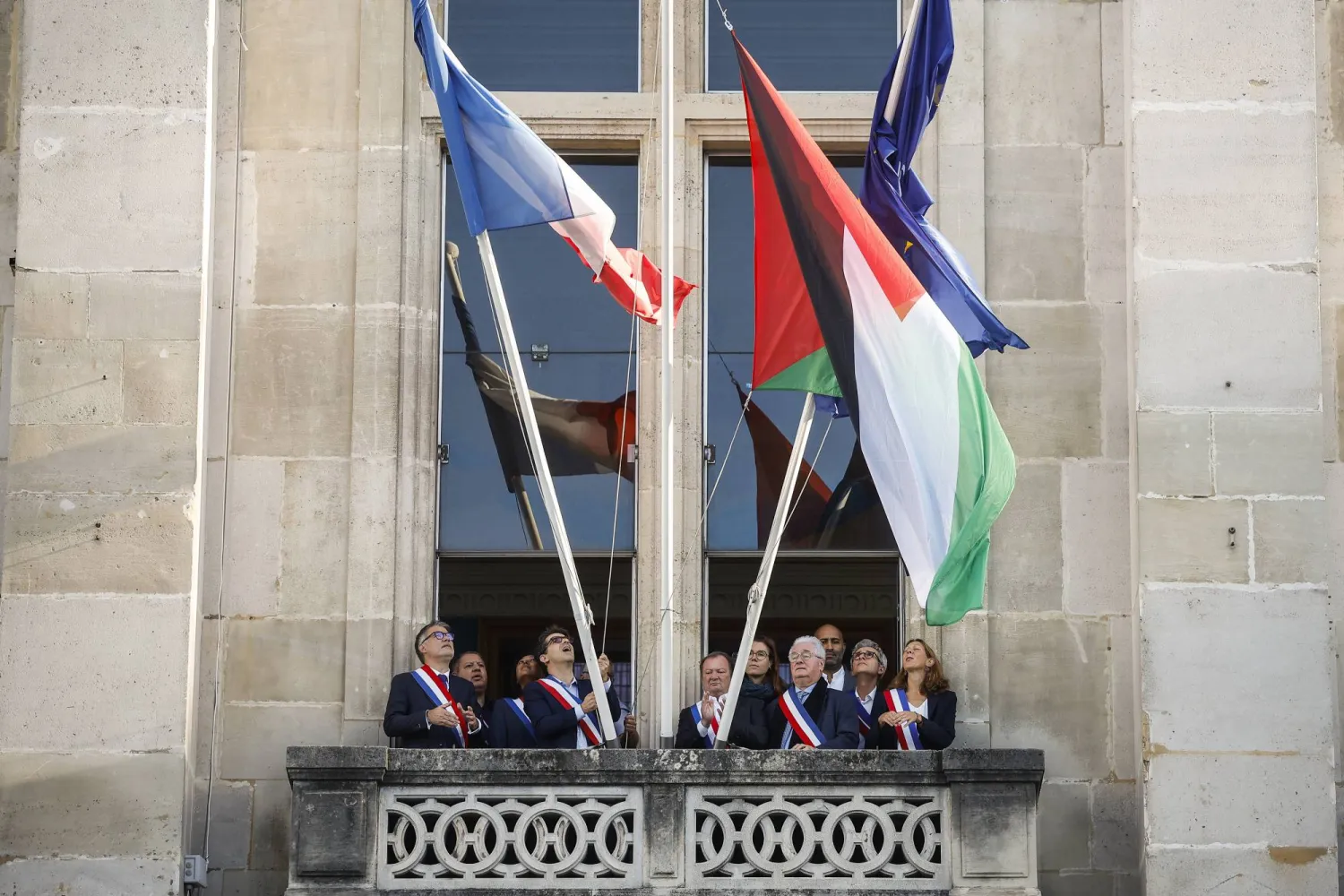 رفع العلم الفلسطيني يوم الاثنين صباحاً على واجهة مبنى بلدية سان دوني الواقعة على مدخل باريس الشمالي (إ.ب.أ)