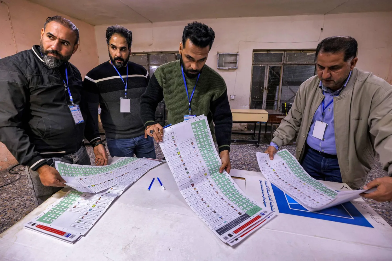 موظفو لجنة الانتخابات يفرزون بطاقات الاقتراع في مركز بـ«مدينة الصدر» شرق بغداد (أرشيفية - أ.ف.ب)