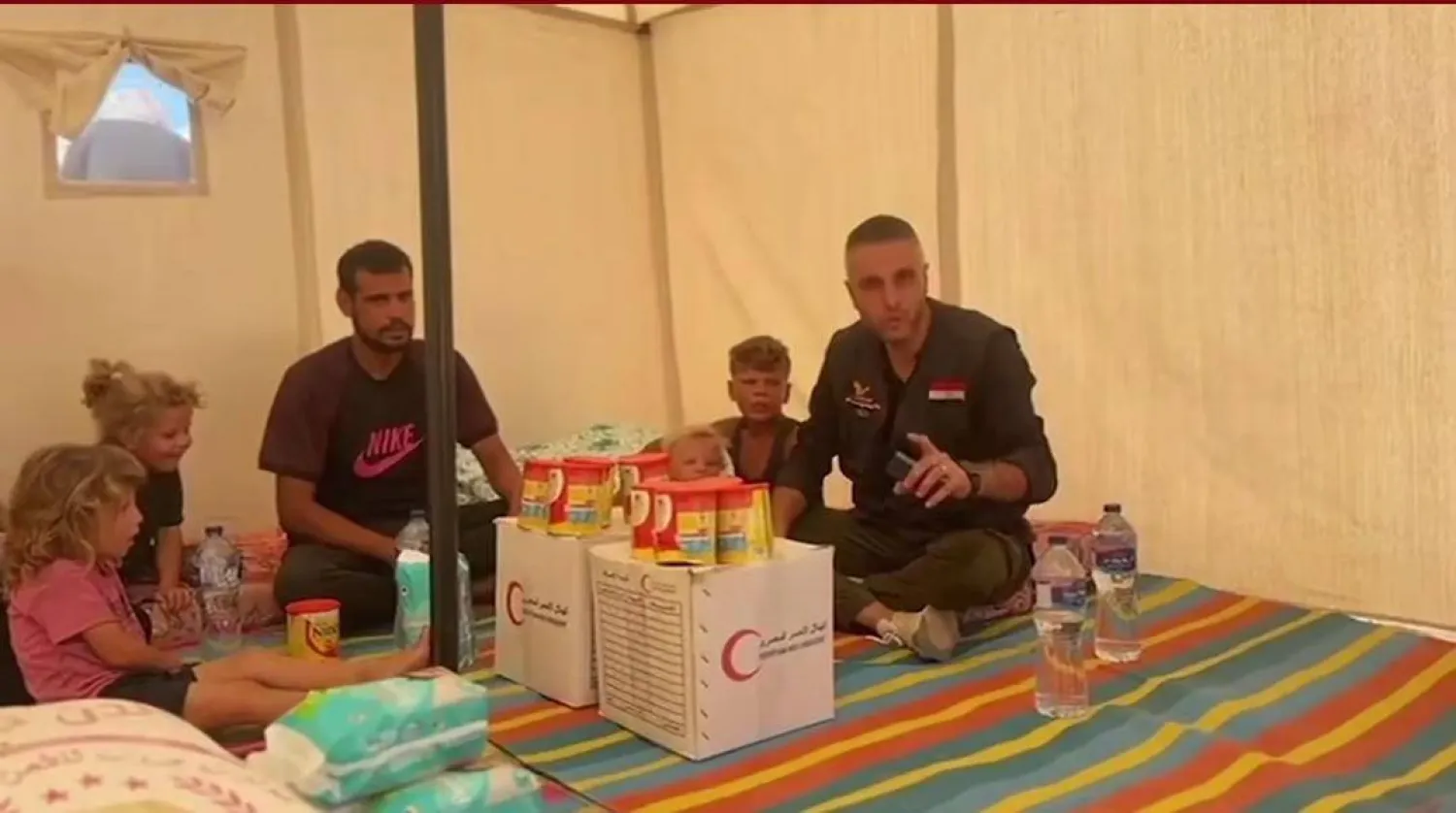 أعضاء اللجنة المصرية لإغاثة أهالي قطاع غزة يسلمون أسرة الطفلين ملابس وأغذية (اللجنة)