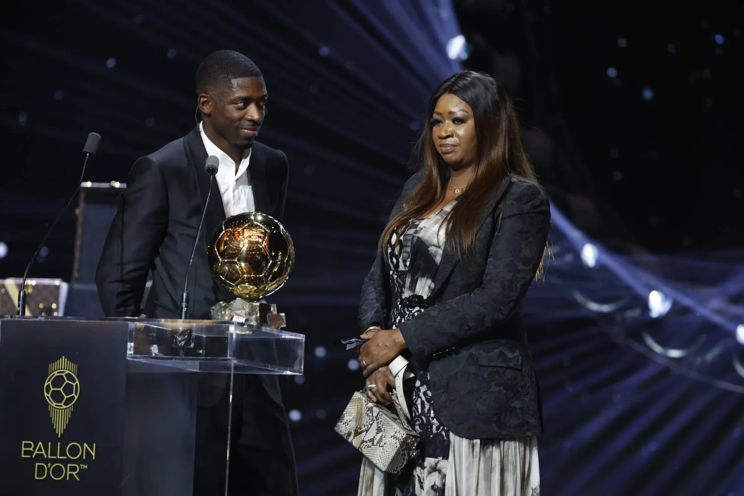 المهاجم الفرنسي عثمان ديمبيلي يحتفل بالكرة الذهبية إلى جوار والدته (إ.ب.أ)