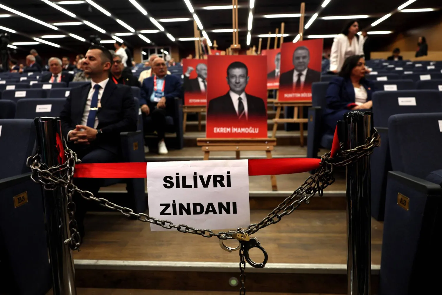 An image of jailed Istanbul Ekrem Imamoglu (C) and other detained municipal employees are displayed behind a sign that reads 'Silivri Prison' during Türkiye's opposition opposition party, Republican People's Party (CHP) extraordinary congress, in Ankara, on September 21, 2025. (Photo by Adem ALTAN / AFP)