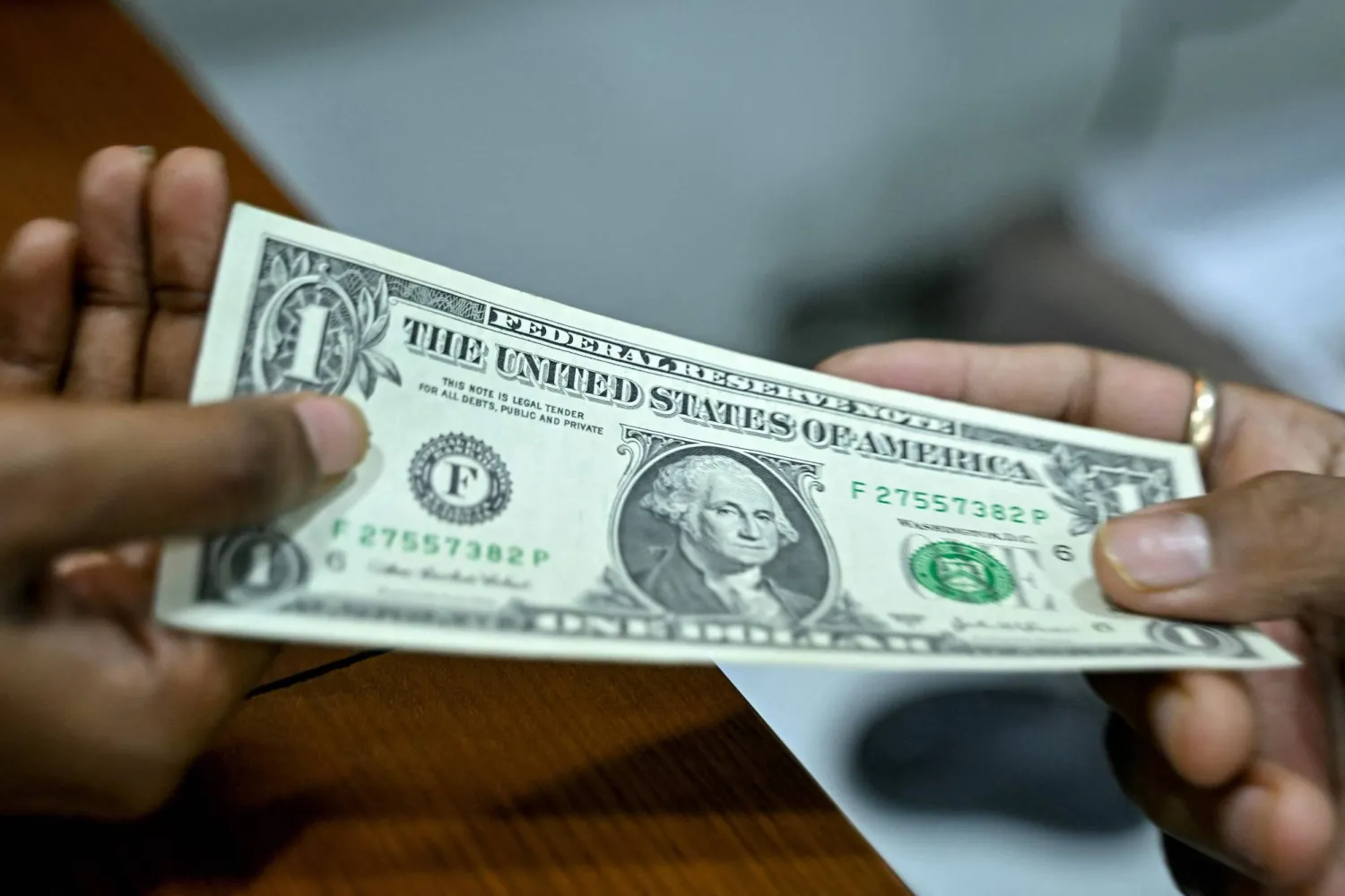 امرأة تصرف دولاراً أميركياً في بنغالورو (أ.ف.ب)