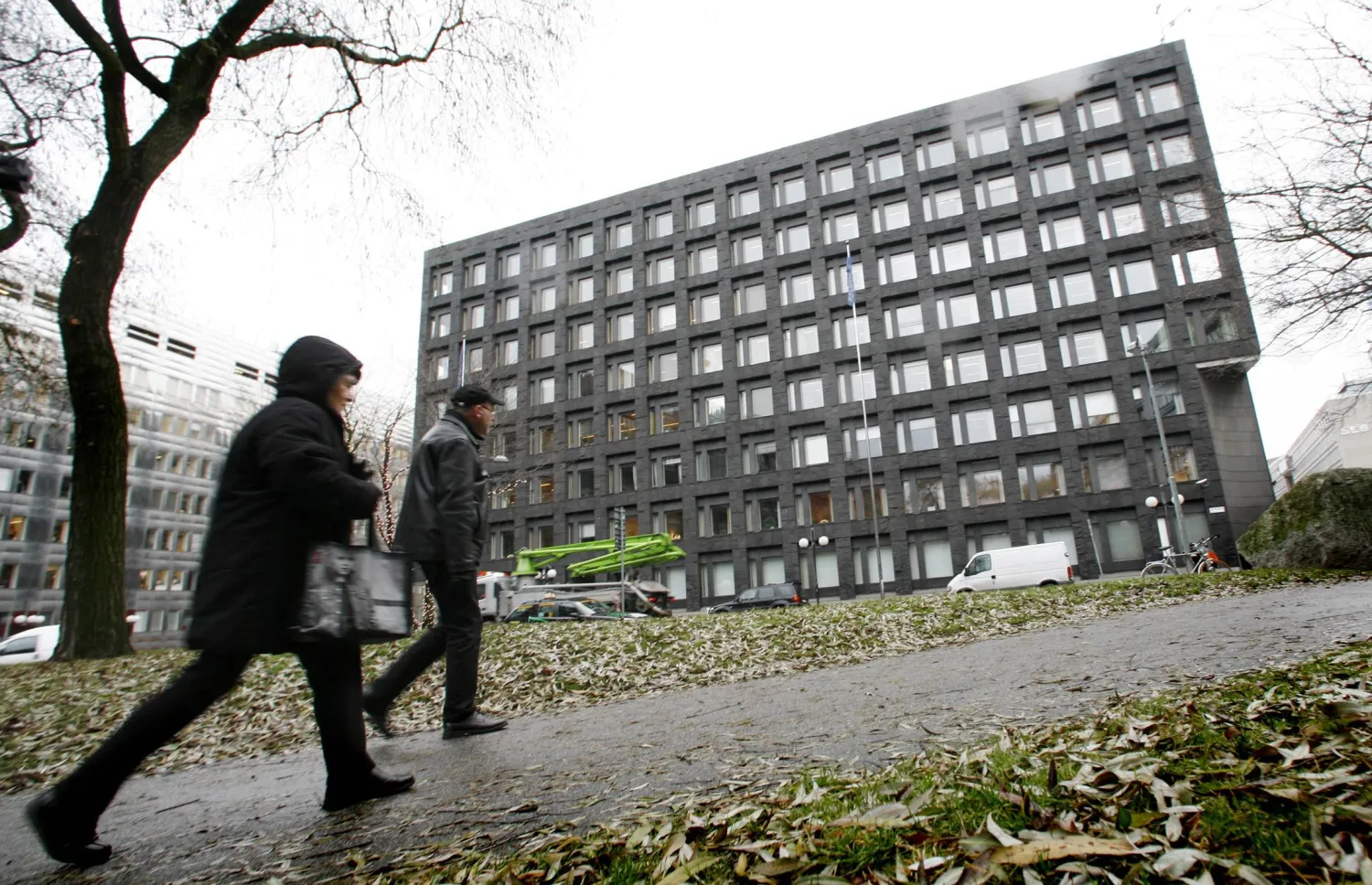 مشاة يمرون أمام مبنى البنك المركزي السويدي وسط استوكهولم (رويترز)