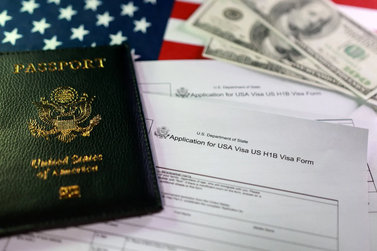 A US flag, a passport, mock US dollars and US H-1B Visa application forms are seen in this illustration taken, September 22, 2025. REUTERS/Dado Ruvic/Illustration
