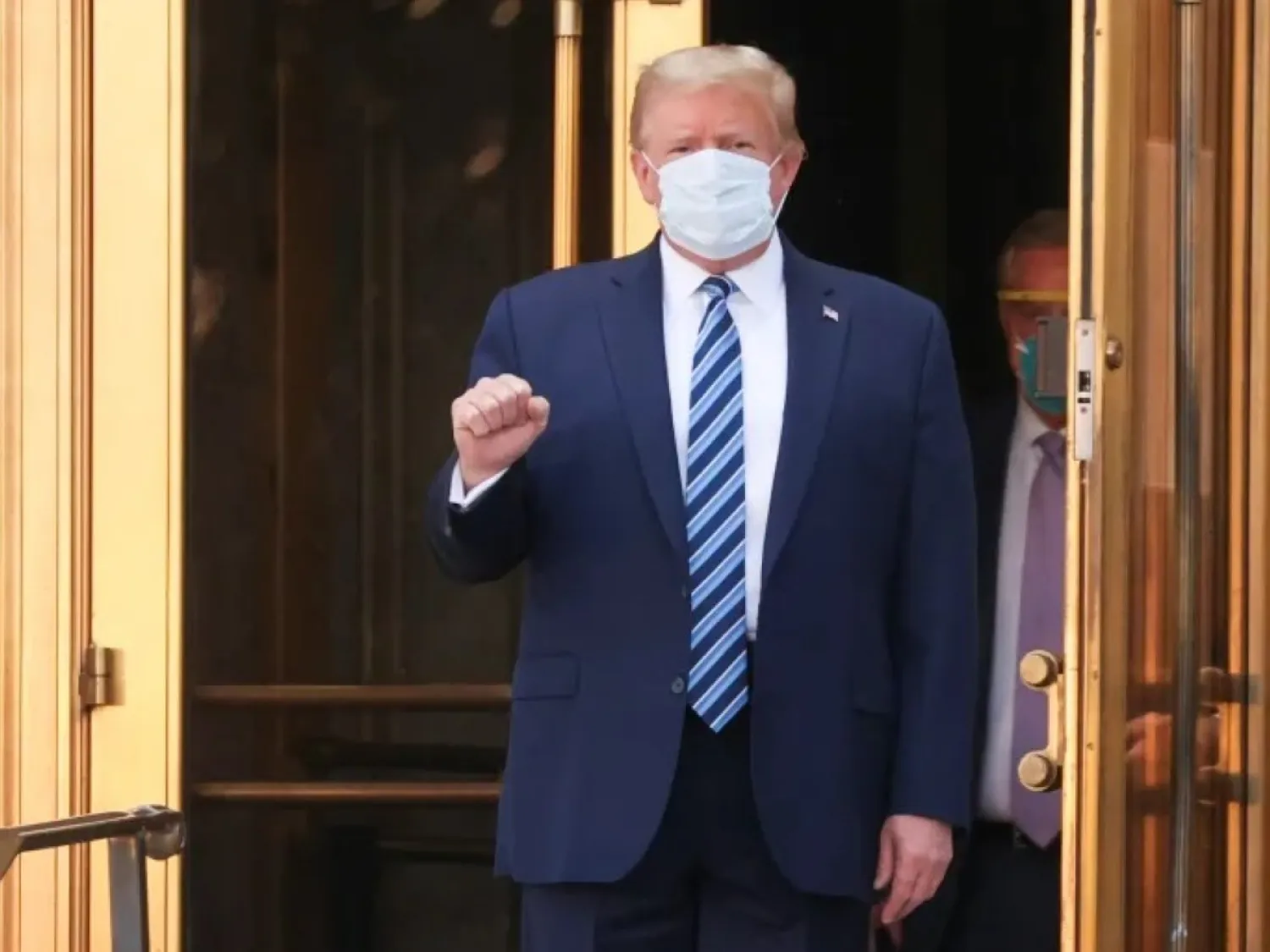 دونالد ترمب يرتدي الكمامة بعد إصابته بكرونا ورفضه البقاء في مستشفى والتر ريد العسكري الوطني لفترة طويلة للعلاج وغادر المستشفى بعد ثلاثة أيام عام 2020 (أرشيفية- رويترز)