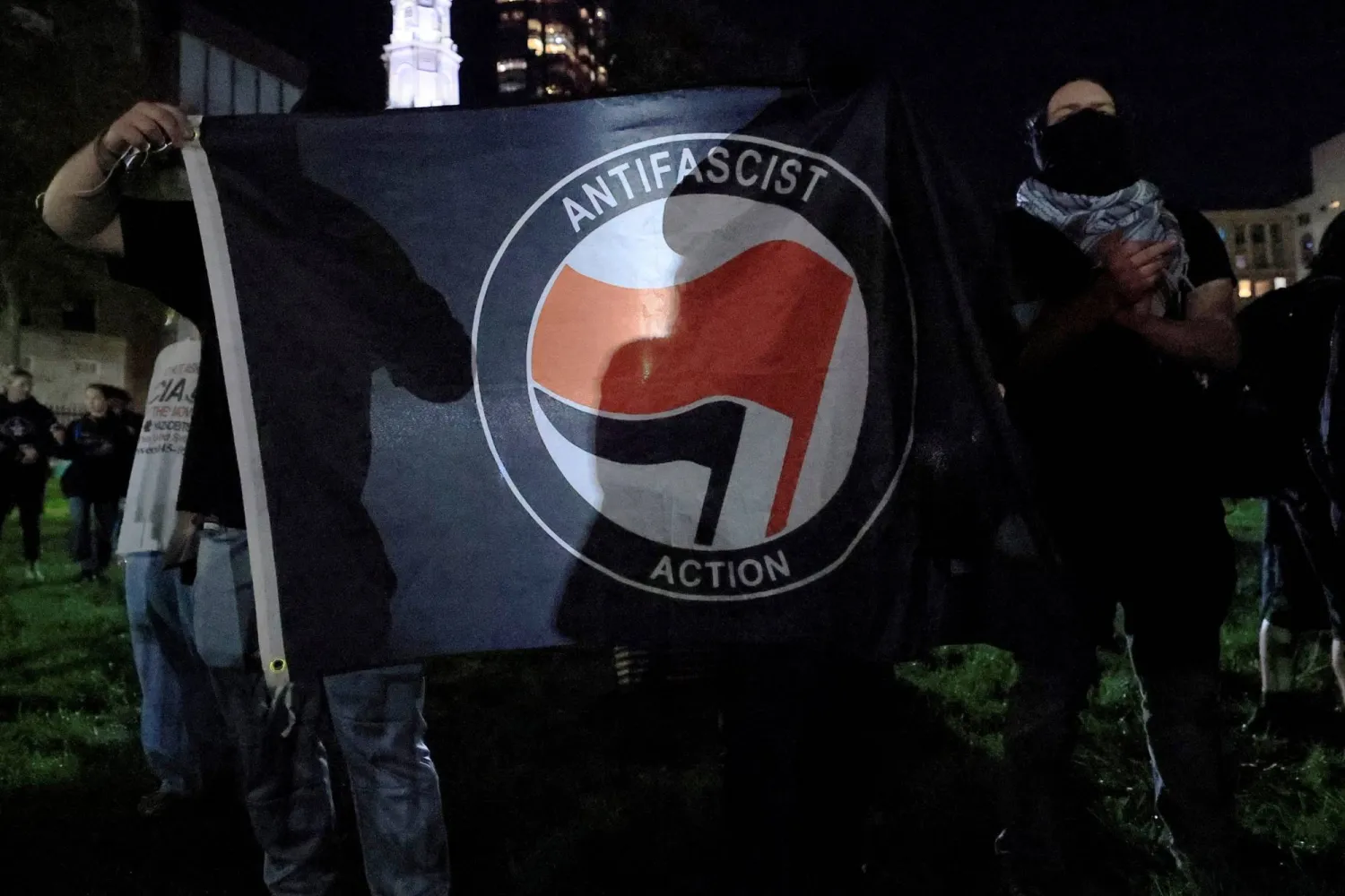 يحمل متظاهرون مضادون علم «العمل المناهض للفاشية» خارج وقفة احتجاجية يوم 18 سبتمبر 2025 للصلاة من أجل تشارلي كيرك الناشط والمعلق اليميني الأميركي وحليف الرئيس الأميركي دونالد ترمب الذي قُتل يوم 10 سبتمبر في بوسطن بماساتشوستس بالولايات المتحدة (رويترز)
