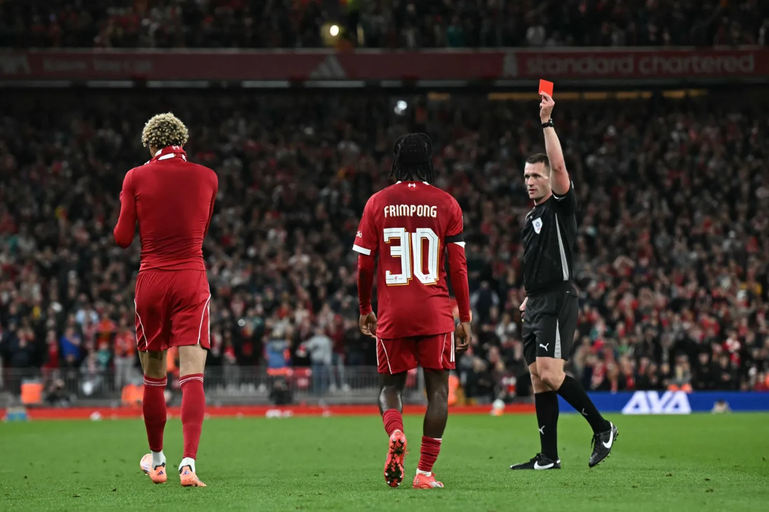 English referee Thomas Bramall (R) shows a red card to Liverpool's French striker #22 Hugo Ekitike (L) after he takes off his shirt celebrating scoring their second goal during the English League Cup third round football match between Liverpool and Southampton at Anfield in Liverpool, northwest England on September 23, 2025. (AFP)