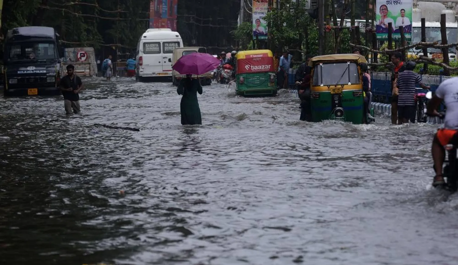 People make their way through a waterlogged street after heavy showers in the eastern Indian city of Kolkata, 23 September 2025. (EPA)