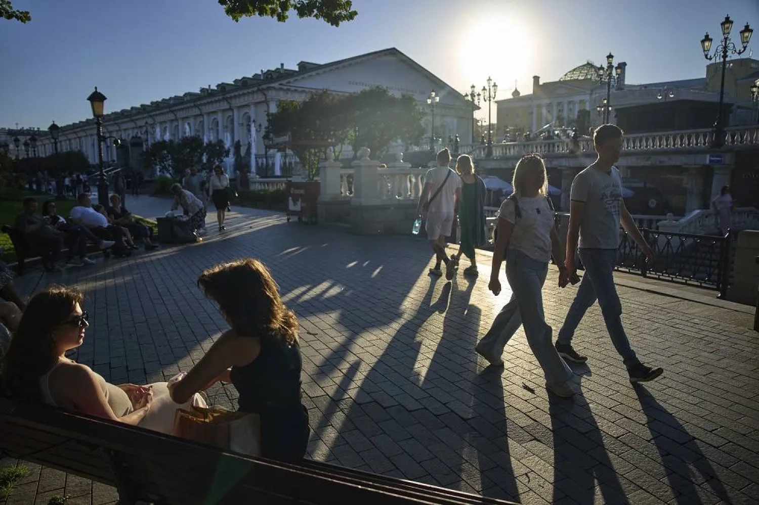 People stroll in Manezhnaya Square near the Kremlin Wall, enjoying a warm sunset in Moscow, Russia, Monday, Sept. 22, 2025. (AP)