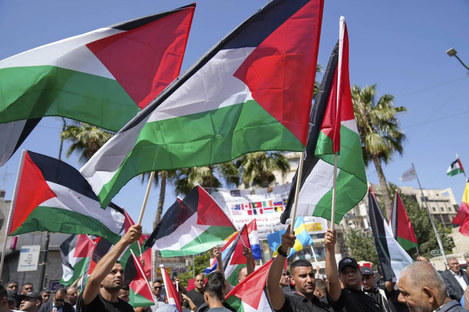 مواطنون يحملون الأعلام الفلسطينية خلال مظاهرة للتضامن مع غزة في الضفة الغربية (أ.ب)