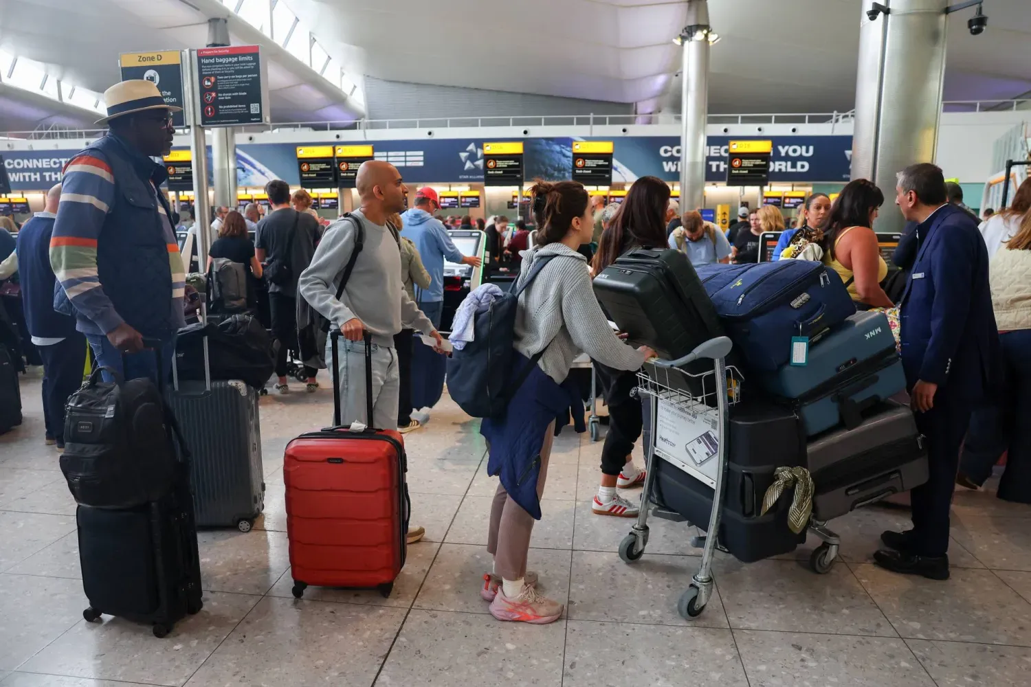 Siber saldırı sonucu Avrupa'nın büyük havalimanlarını etkileyen check-in sistemlerinin bozulmasının ardından yolcular Heathrow Havalimanı'nın 2. Terminali'nde bekliyor (Reuters)