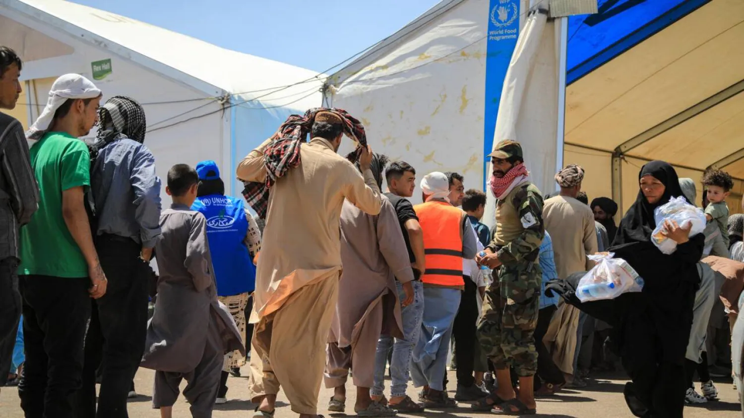 Newly arrived Afghan migrants from Iran queue to receive food packages at the Islam Qala border crossing in Herat. Mohsen KARIMI / AFP

