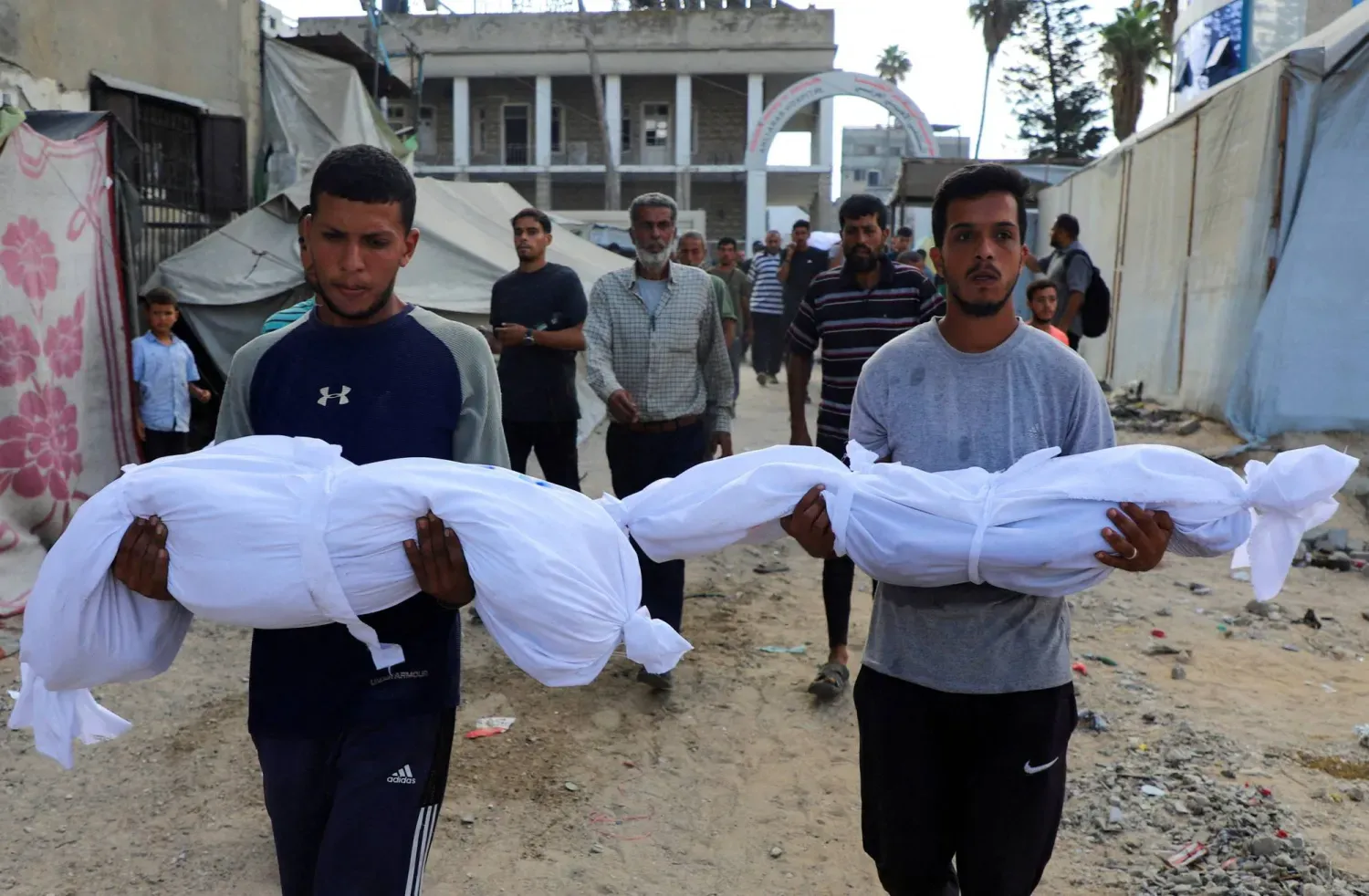 İsrail'in Gazze'ye düzenlediği hava saldırısında hayatını kaybeden iki çocuğun cenazesini taşıyan Filistinliler (Reuters)