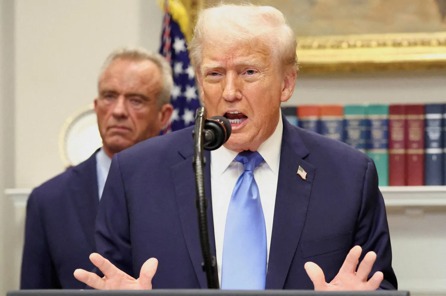 FILE PHOTO: US President Donald Trump, in front of US Secretary of Health and Human Services Robert F. Kennedy Jr., delivers remarks linking autism to childhood vaccines and to the use of popular pain medication Tylenol for pregnant women and children, claims which are not backed by decades of science, at the White House in Washington, D.C., US, September 22, 2025. REUTERS/Kevin Lamarque/File Photo