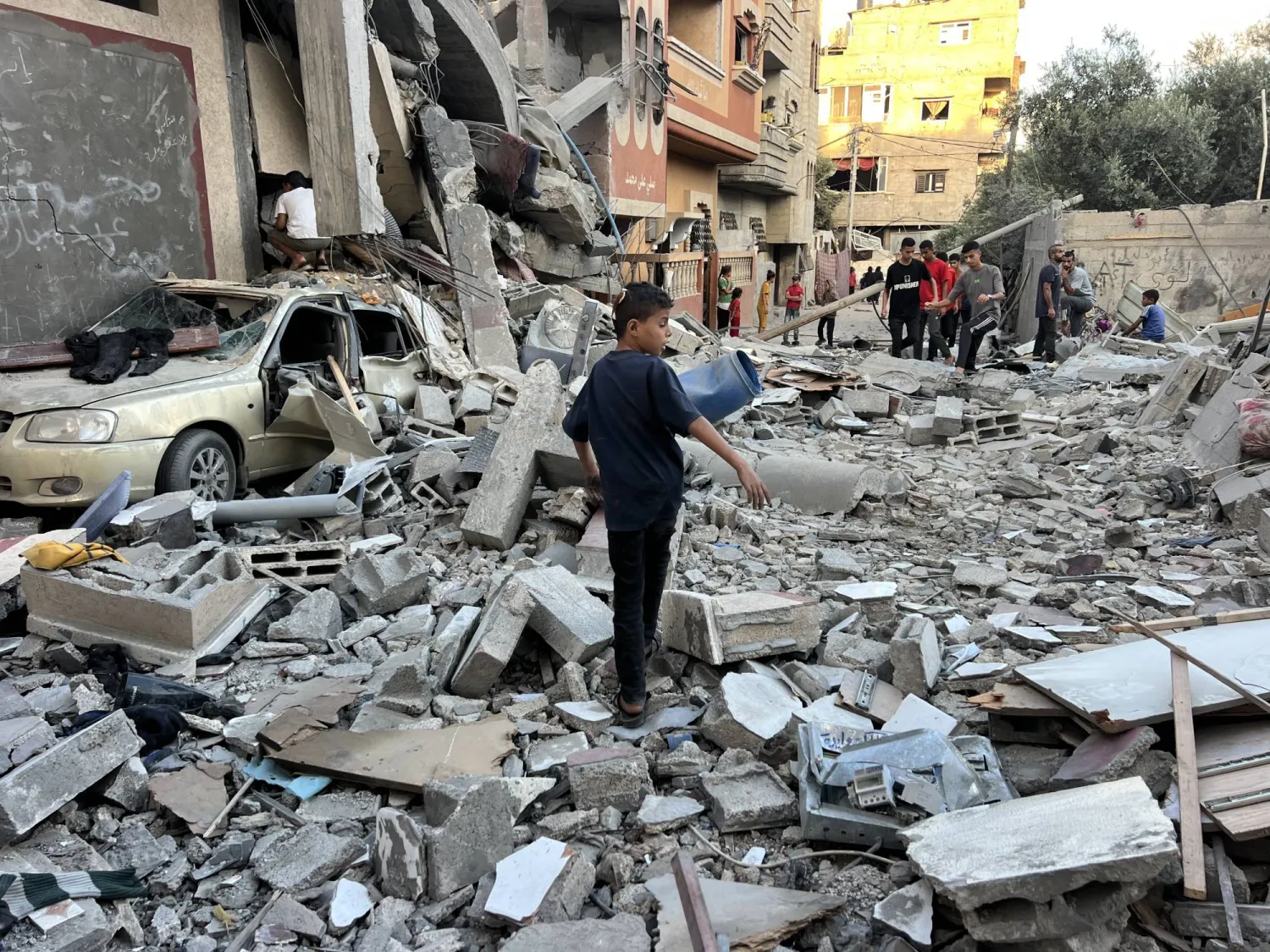 فلسطينيون يتفقدون الدمار الناجم عن هجوم إسرائيلي بمخيم النصيرات للاجئين بوسط قطاع غزة (د.ب.أ)