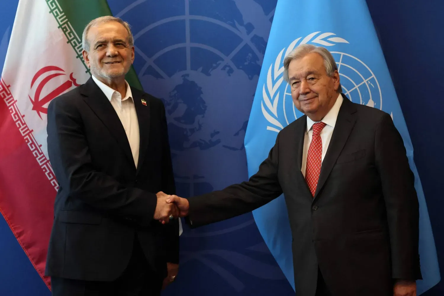 BM Genel Sekreteri Antonio Guterres, İran Cumhurbaşkanı Mesud Pezeşkiyan ile el sıkışıyor (AFP)