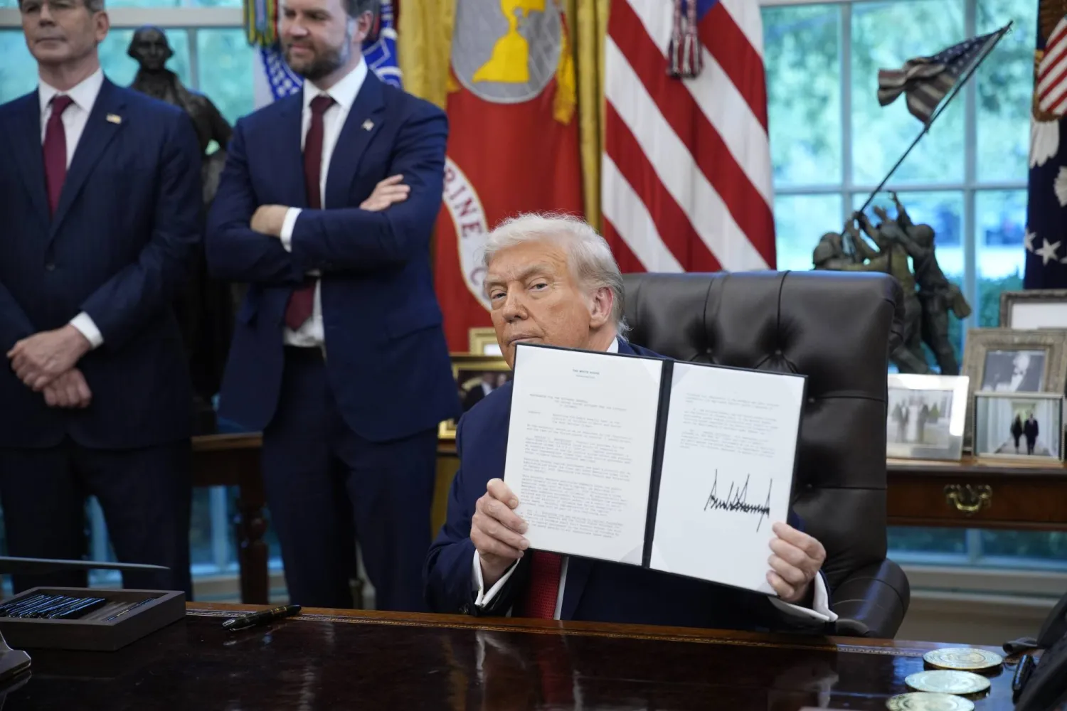 الرئيس الأميركي دونالد ترمب يوقع أوامر تنفيذية في المكتب البيضاوي بالبيت الأبيض (إ.ب.أ)