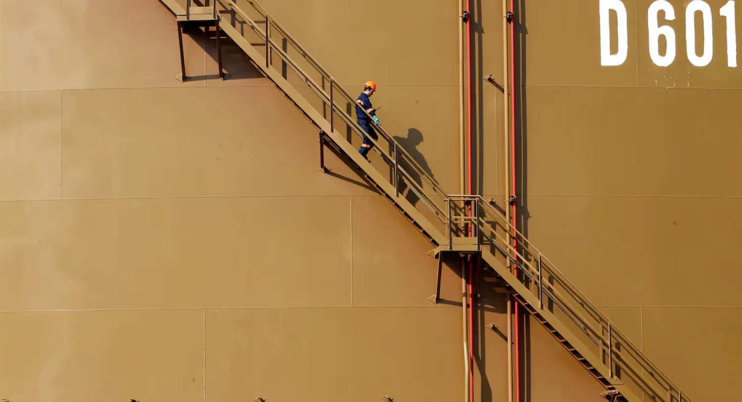 A worker walks down the stairs of an oil tank at Türkiye Mediterranean port of Ceyhan, which is run by state-owned Petroleum Pipeline Corporation (BOTAS), some 70 km (43.5 miles) from Adana February 19, 2014. REUTERS/Umit Bektas/File Photo 