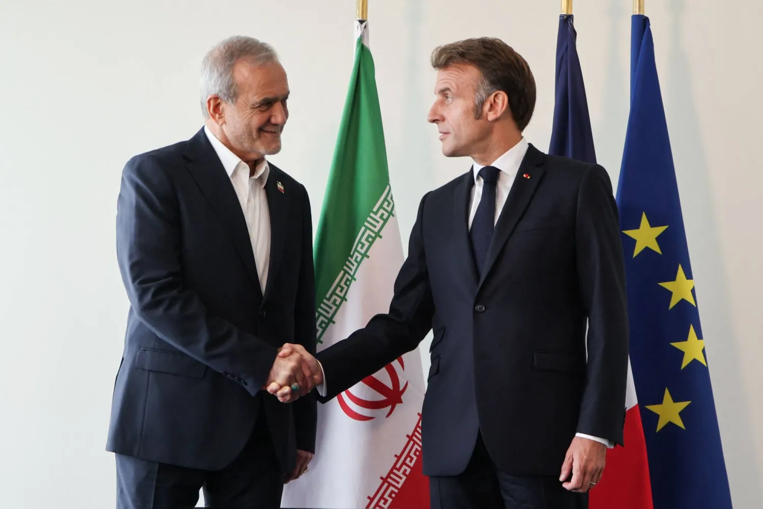 الرئيسان الفرنسي إيمانويل ماكرون والإيراني مسعود بزشكيان يتصافحان الأربعاء في نيويورك قبل اجتماعهما على هامش أعمال الجمعية العامة للأمم المتحدة (أ.ف.ب)