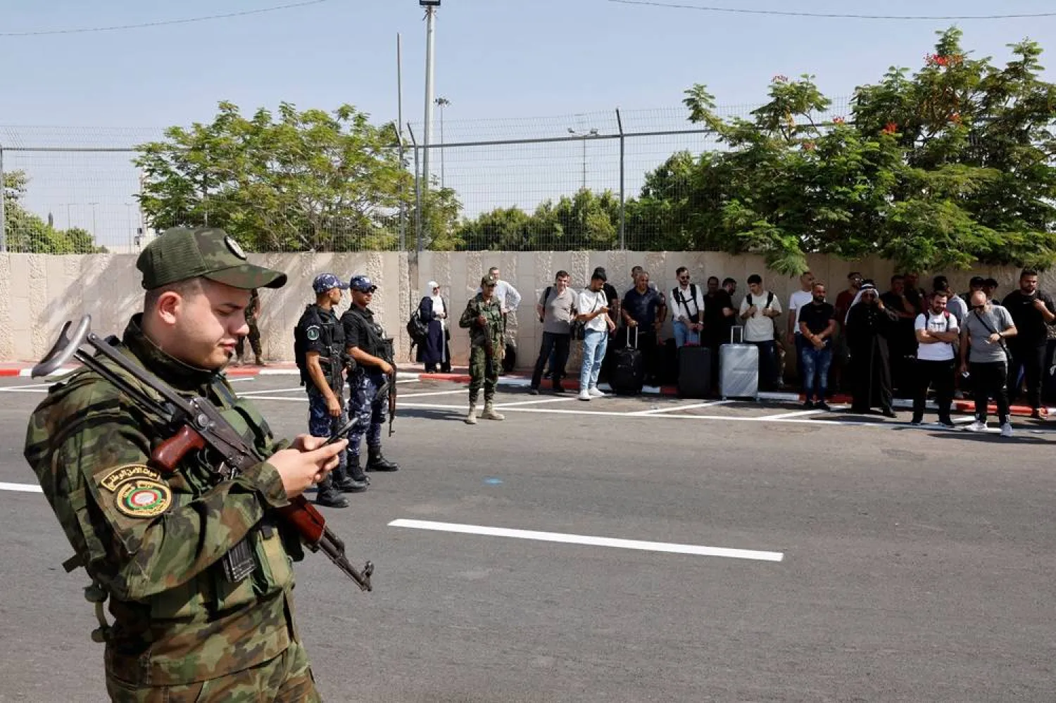Security forces stand guard as Palestinians wait near the Allenby Bridge Crossing in the Israeli-occupied West Bank to travel to Jordan, after Israeli Airports Authority said it will be reopened on Friday, September 26,2025. (Reuters) 