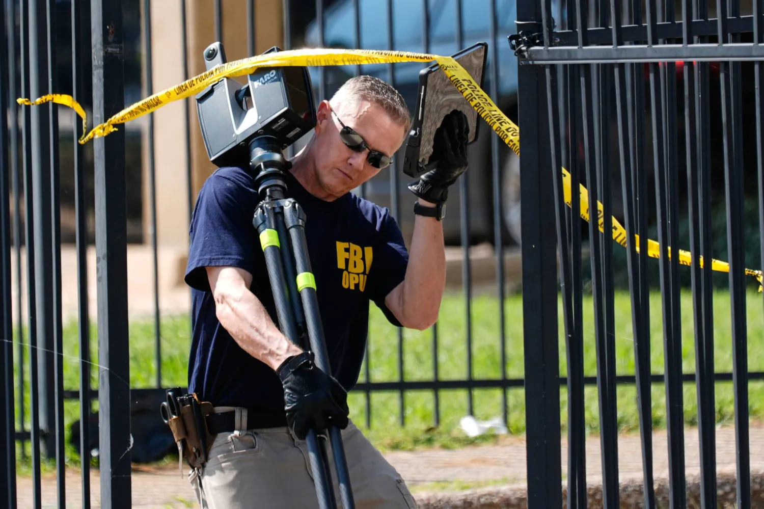 عملاء مكتب التحقيقات الفيدرالي يحققون في مسرح جريمة بدالاس (أ.ب)