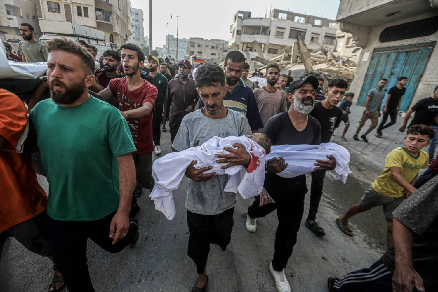 فلسطينيون يحملون جثامين الشهداء اليوم في مدينة غزة (د.ب.أ)