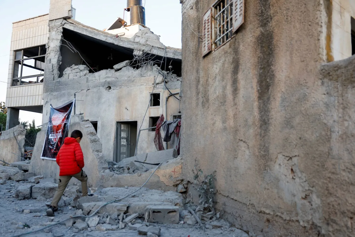 طفل فلسطيني يسير بالقرب من منزل أحد الفلسطينيين بعد أن هدمه الجيش الإسرائيلي خلال عملية في القبيبة بالقرب من رام الله في الضفة الغربية المحتلة (رويترز)