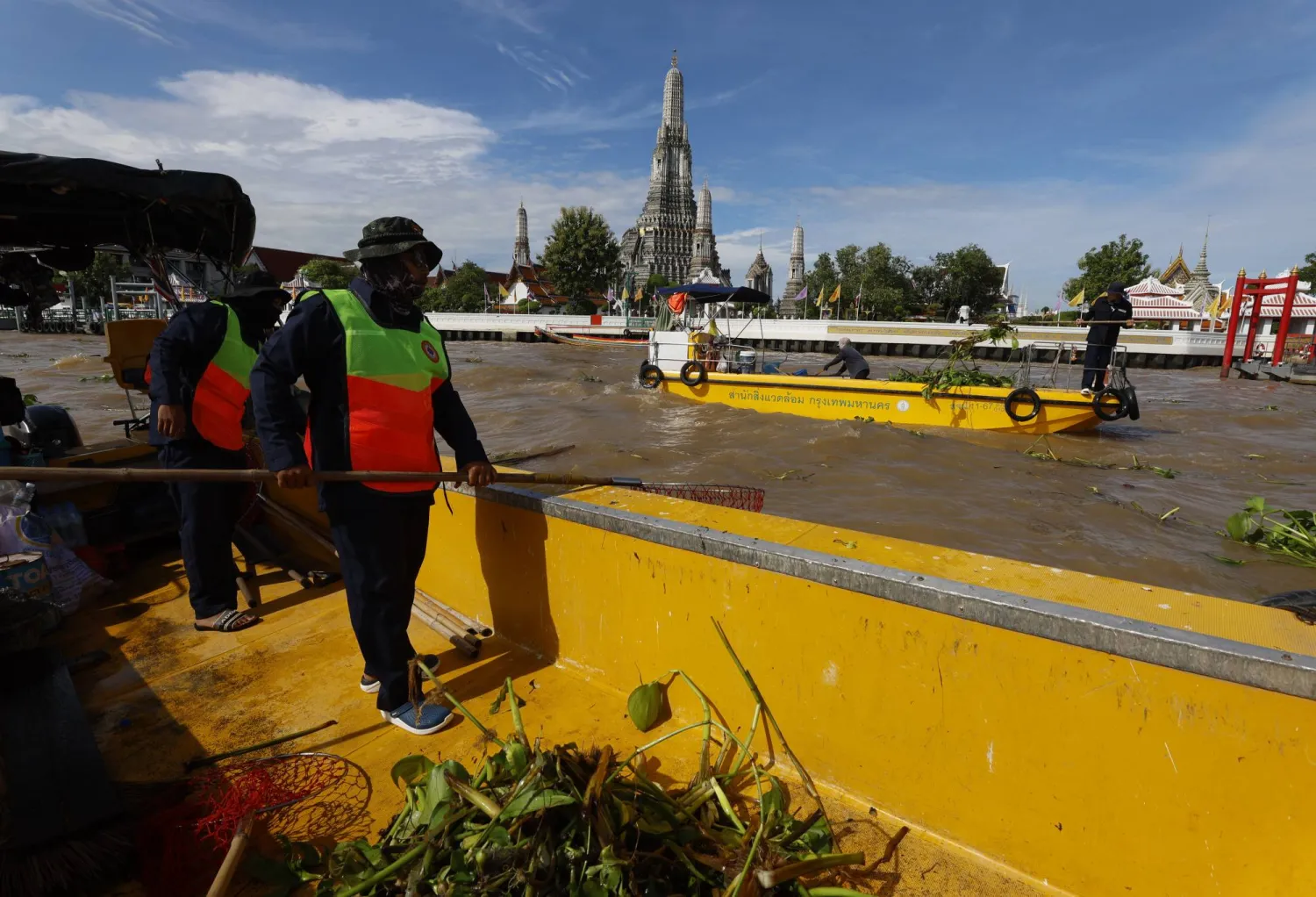 عمال جمع القمامة يزيلون الأعشاب والقمامة من نهر تشاو فرايا في بانكوك (إ.ب.أ)