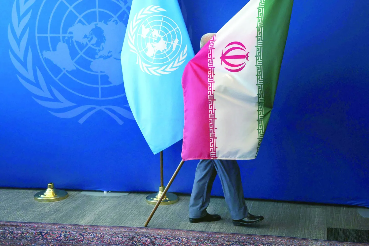رجل يسحب العلم الإيراني من القاعة عقب لقاء الرئيس مسعود بزشكيان بالأمين العام للأمم المتحدة أنطونيو غوتيريش خلال أعمال الجمعية العامة للأمم المتحدة في نيويورك (أ.ف.ب)
