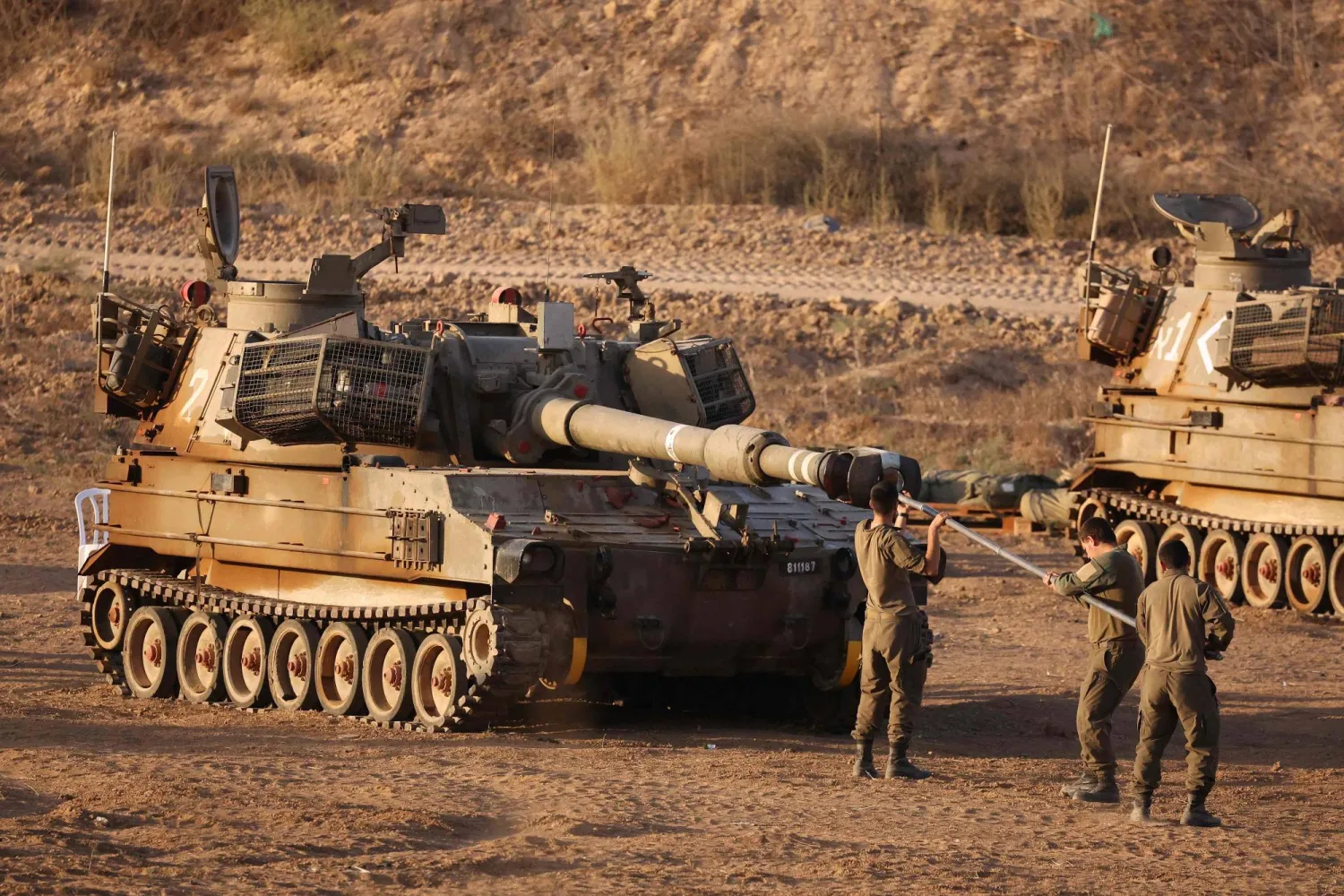 جنود إسرائيليون يعملون على مدفعية تم نشرها على الحدود مع قطاع غزة يوم 25 سبتمبر 2025 (أ.ف.ب)