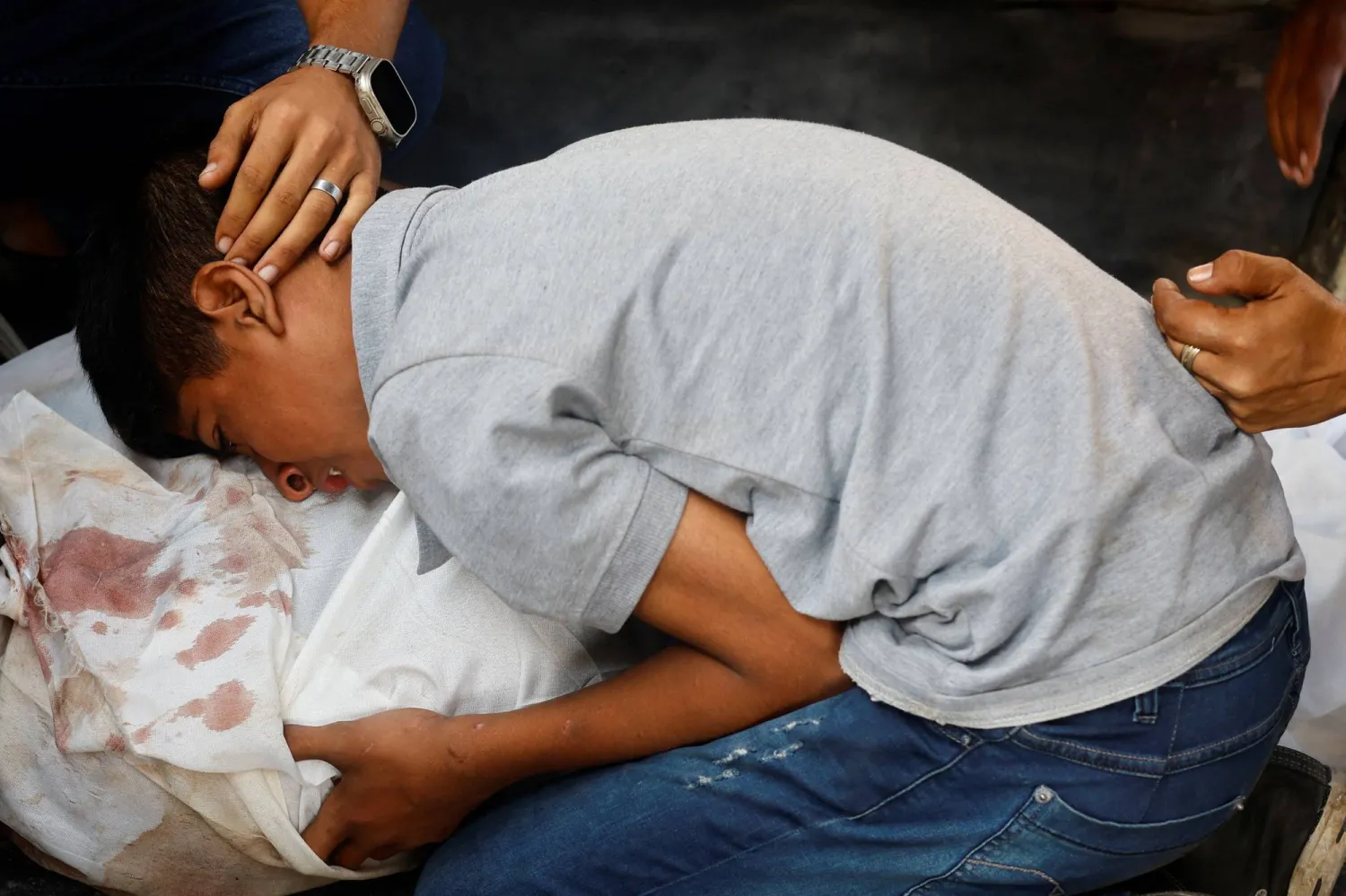 طفل يبكي على والده الذي قتل في غارة إسرائيلية على غزة (رويترز)