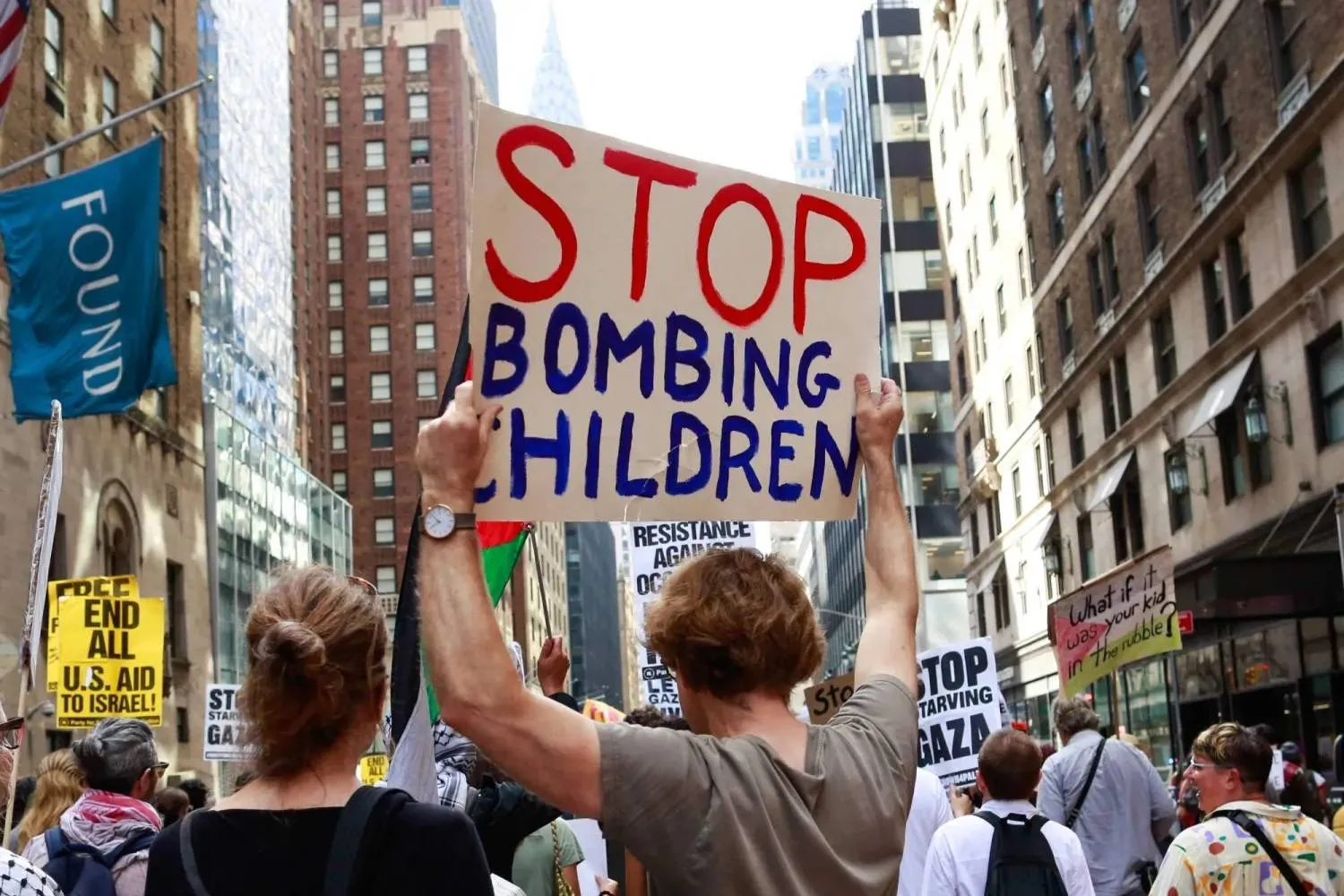 A man holds a sign calling for an end to the bombing of children during a protest against Netanyahu in New York on Friday. (AFP) 