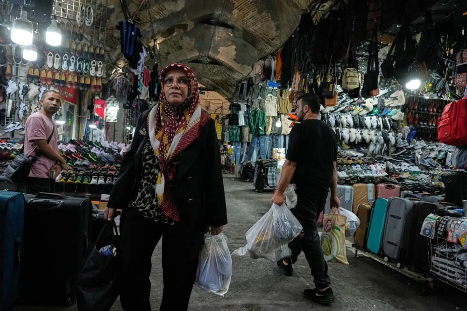  People carry their shopping items at Amin ol-Soltan traditional market in Tehran, Iran, Wednesday, Sept. 24, 2025. (AP) 