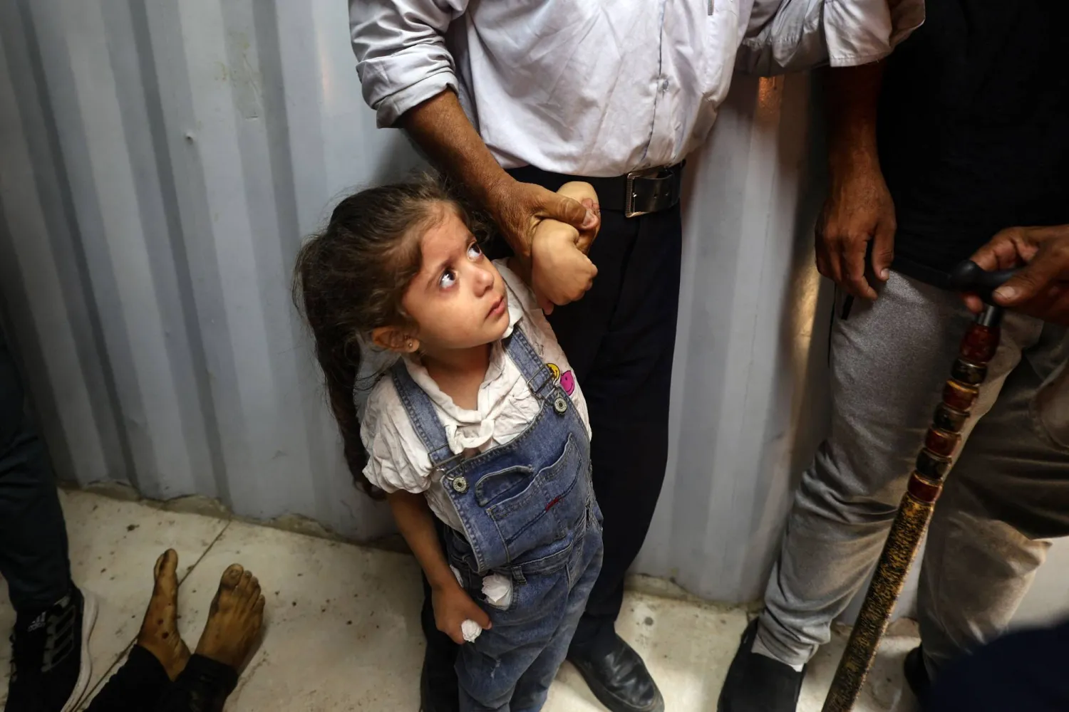 طفلة فلسطينية تقف بالقرب من جثمان أحد القتلى في الغارات الإسرائيلية اليوم في مخيم النصيرات بوسط غزة (أ.ف.ب) 