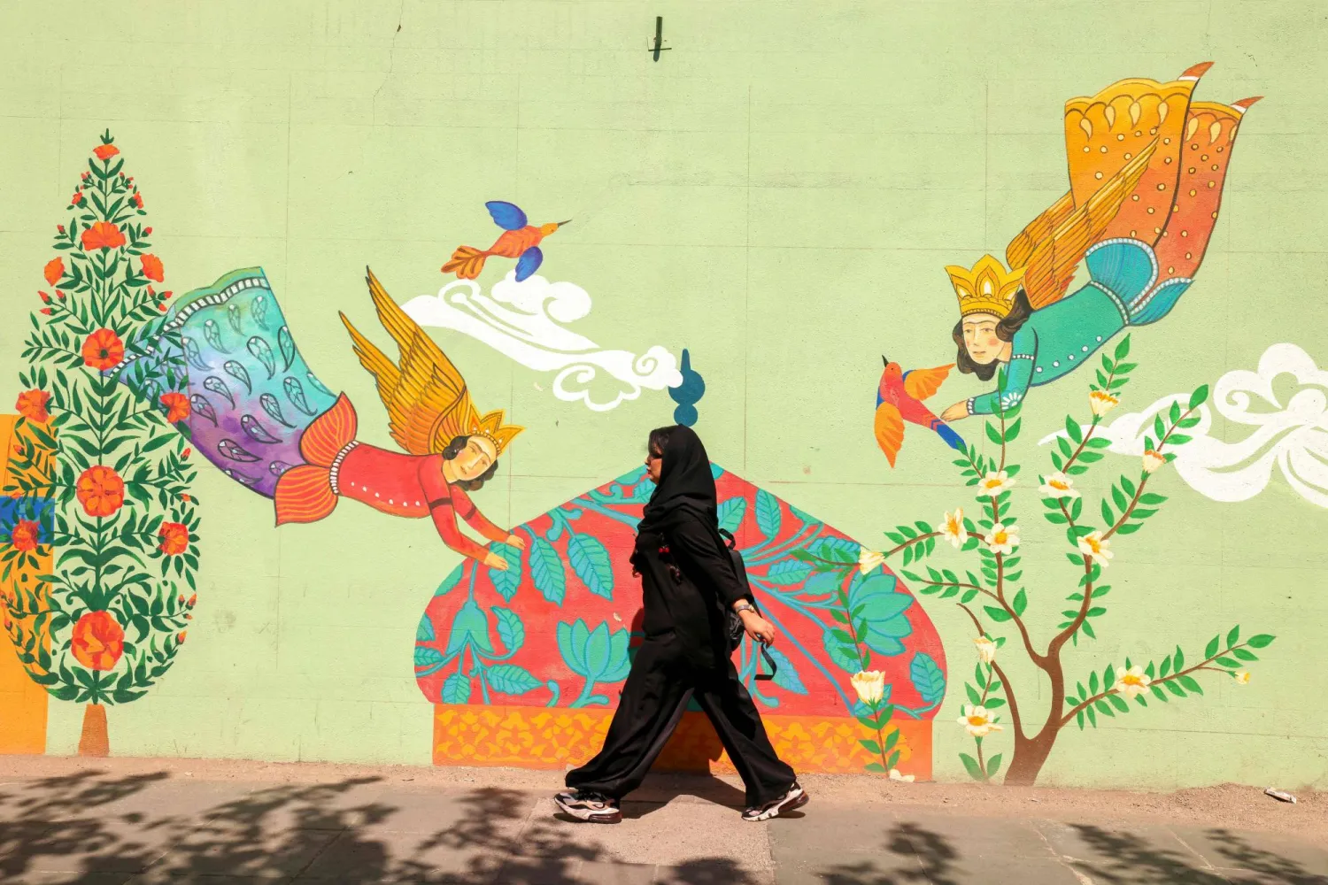 إيرانية تمر بجانب لوحة جدارية في طهران الأحد (أ.ف.ب)