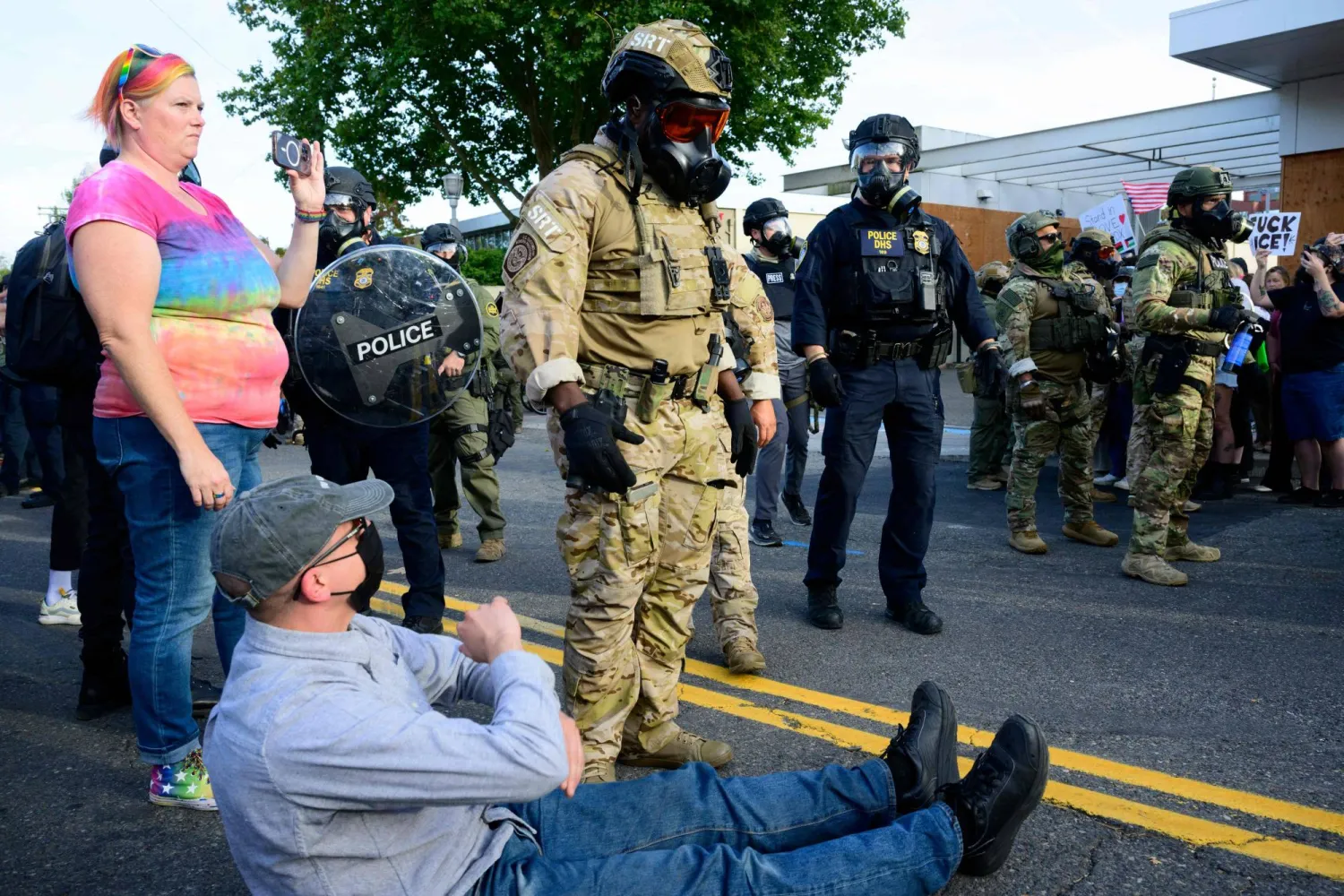 عملاء فيدراليون في مواجهة متظاهرين خارج مبنى إدارة الهجرة والجمارك الأميركية في بورتلاند (أ.ف.ب)