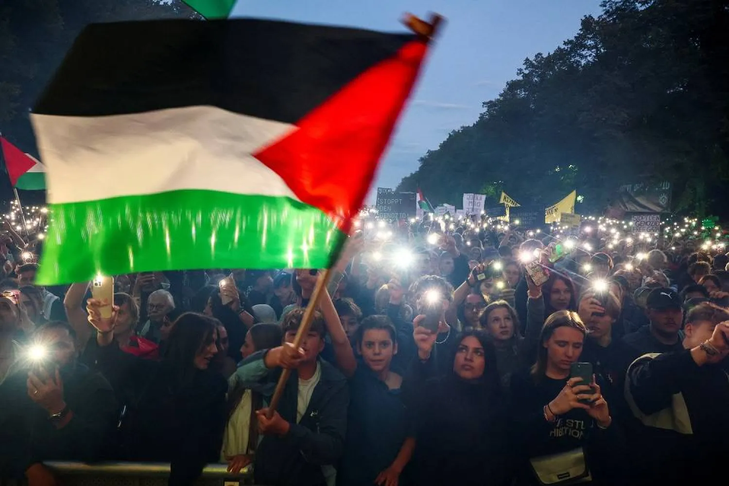 Demonstrators light mobile phones flashlights during the "All eyes on Gaza" rally in Berlin, Germany, September 27, 2025. (Reuters)
