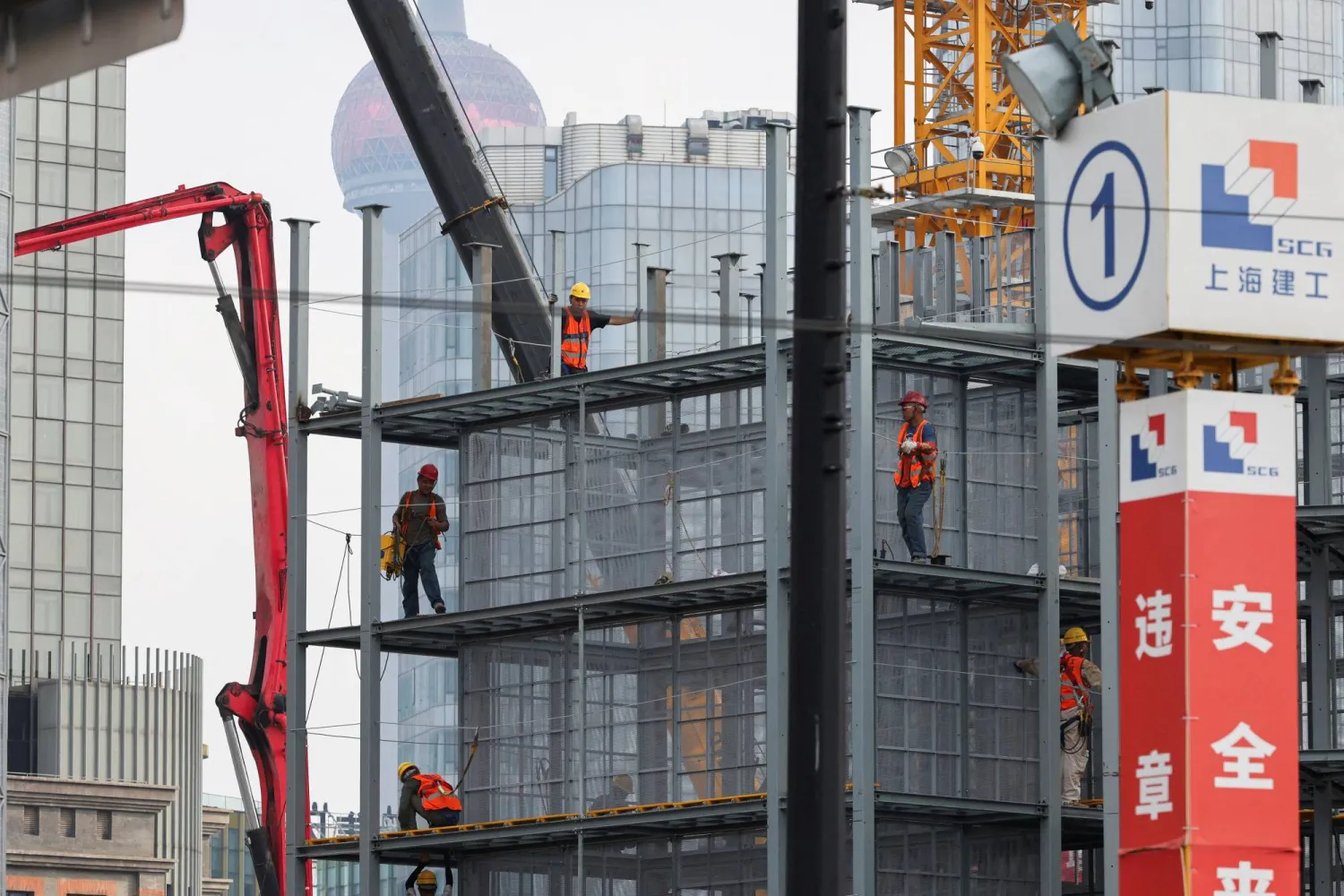 عمال في موقع إنشاءات بمدينة شنغهاي الصينية (رويترز)