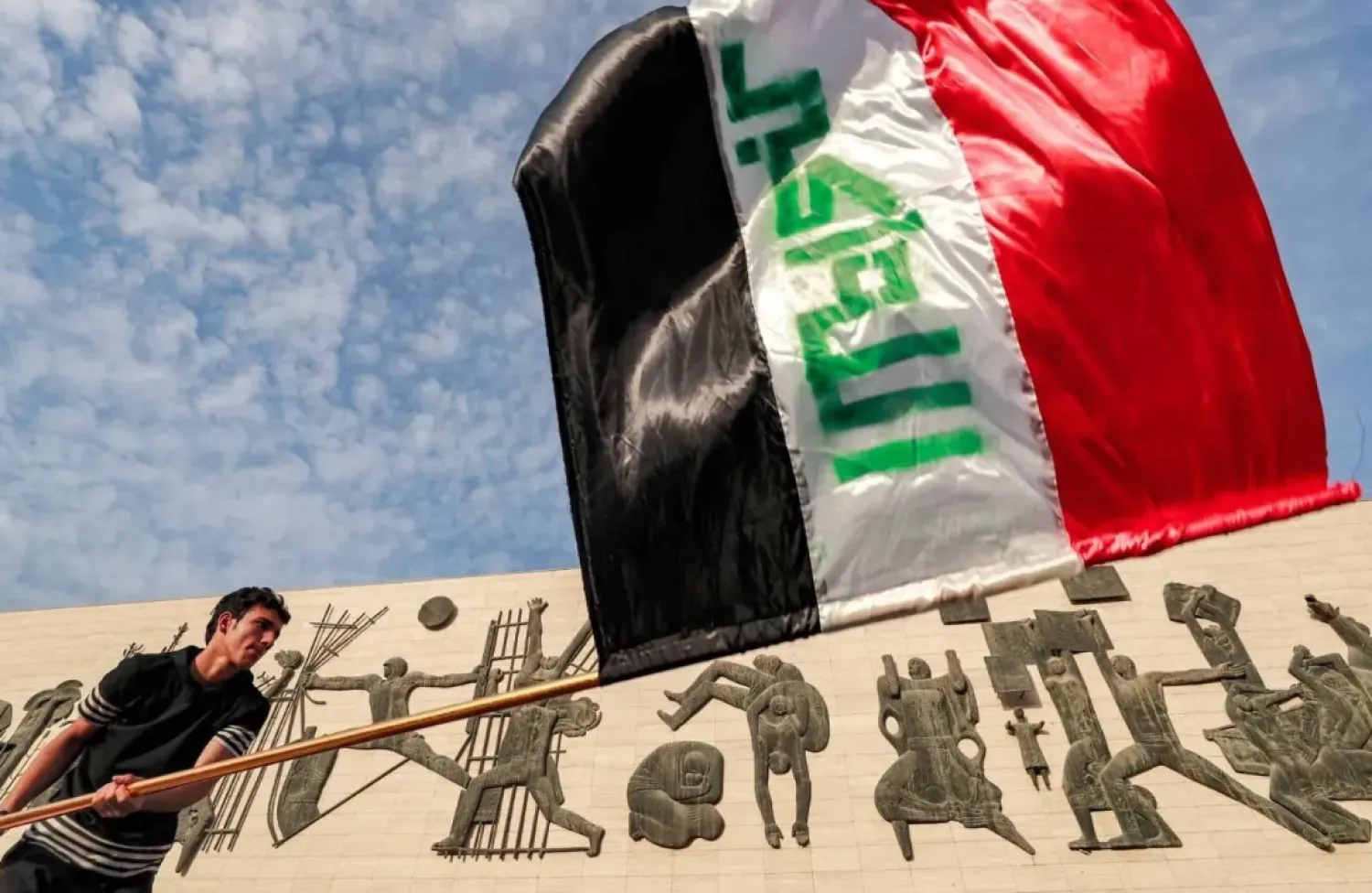 A man waves the Iraqi flag at Tahrir Square in Baghdad (AFP). 
