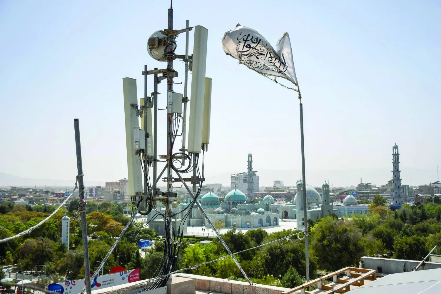 يرفرف عَلم «طالبان» بالقرب من معدات اتصالات مُثبّتة على سطح مبنى يوفر خدمة الإنترنت (أ.ف.ب)