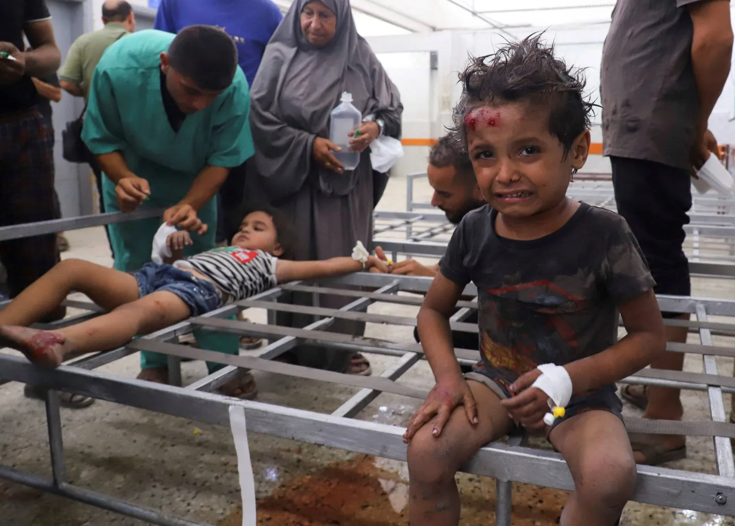 أطفال فلسطينيون جرحى يتلقون العلاج بمستشفى الشفاء بعد إصابتهم في غارة إسرائيلية على قطاع غزة (رويترز)